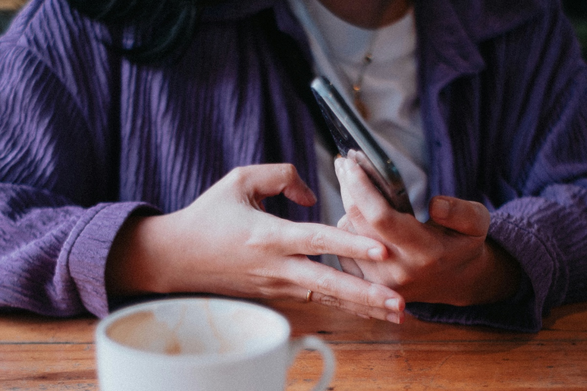 Membalas review lewat ponsel di meja kafe